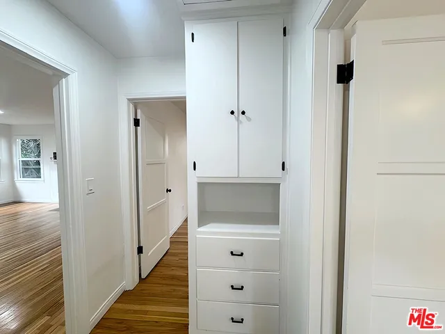a view of a hallway with wooden floor and closet