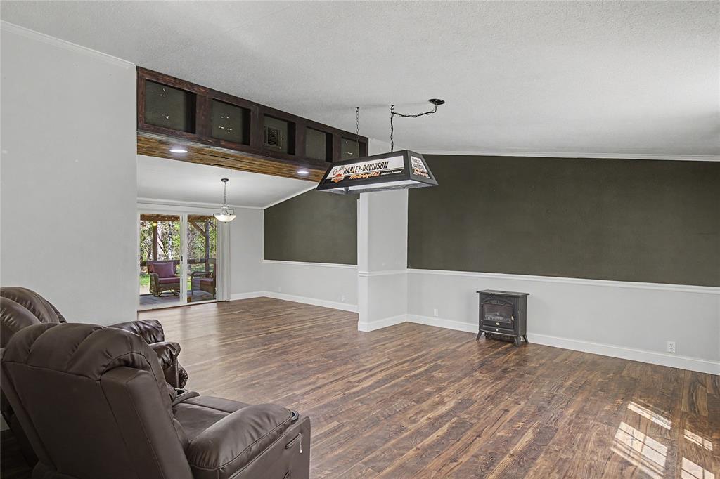 1701 Central Road Weatherford, TX 76088 - Photo 13 of 40 Living area or formal dining featuring ornamental molding, dark wood-style flooring with a view of the breakfast/dining area with glass sliding door.