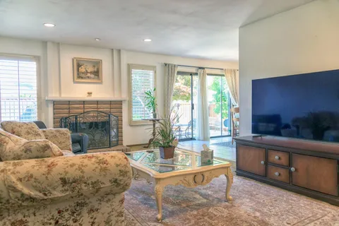a living room with furniture a large window and a fireplace