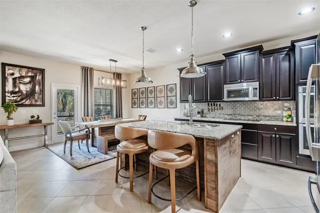 a kitchen with stainless steel appliances granite countertop a sink a stove and a wooden floor