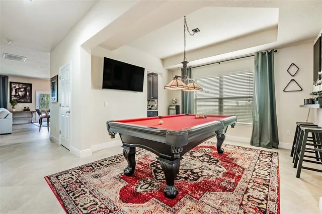 a living room with patio furniture and a flat screen tv