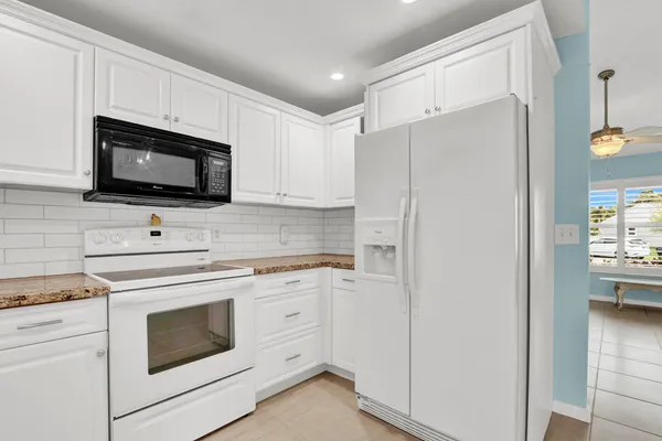 a kitchen with stainless steel appliances white cabinets and a refrigerator
