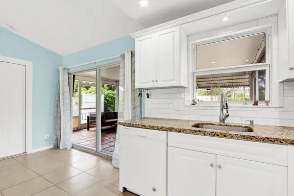 a kitchen with granite countertop a sink and a window