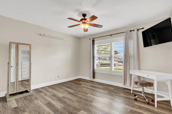 a view of a livingroom with a ceiling fan & hardwood floor