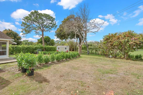 a view of a house with a big yard and large trees