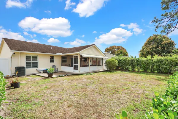 a view of a house with backyard and sitting area