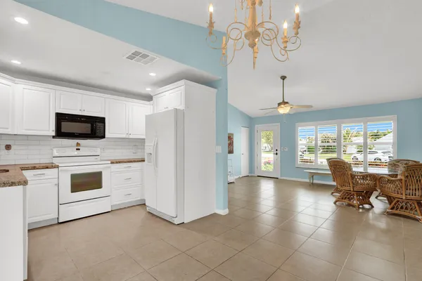 a view of a livingroom with furniture cabinet a flat screen tv and a chandelier