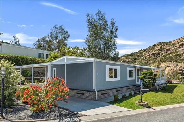 a front view of a house with a yard and potted plants
