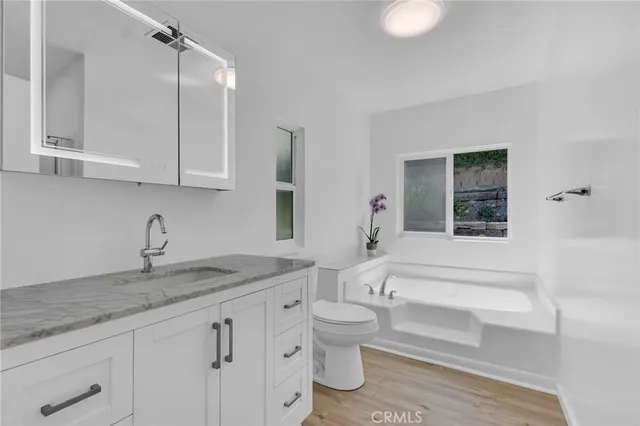 a bathroom with a granite countertop sink and cabinets