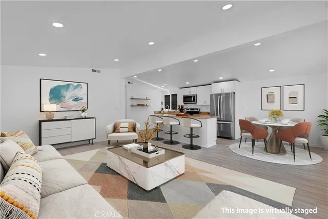 a living room with furniture kitchen view and a dining table