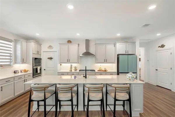 a kitchen with center island white cabinets and stainless steel appliances