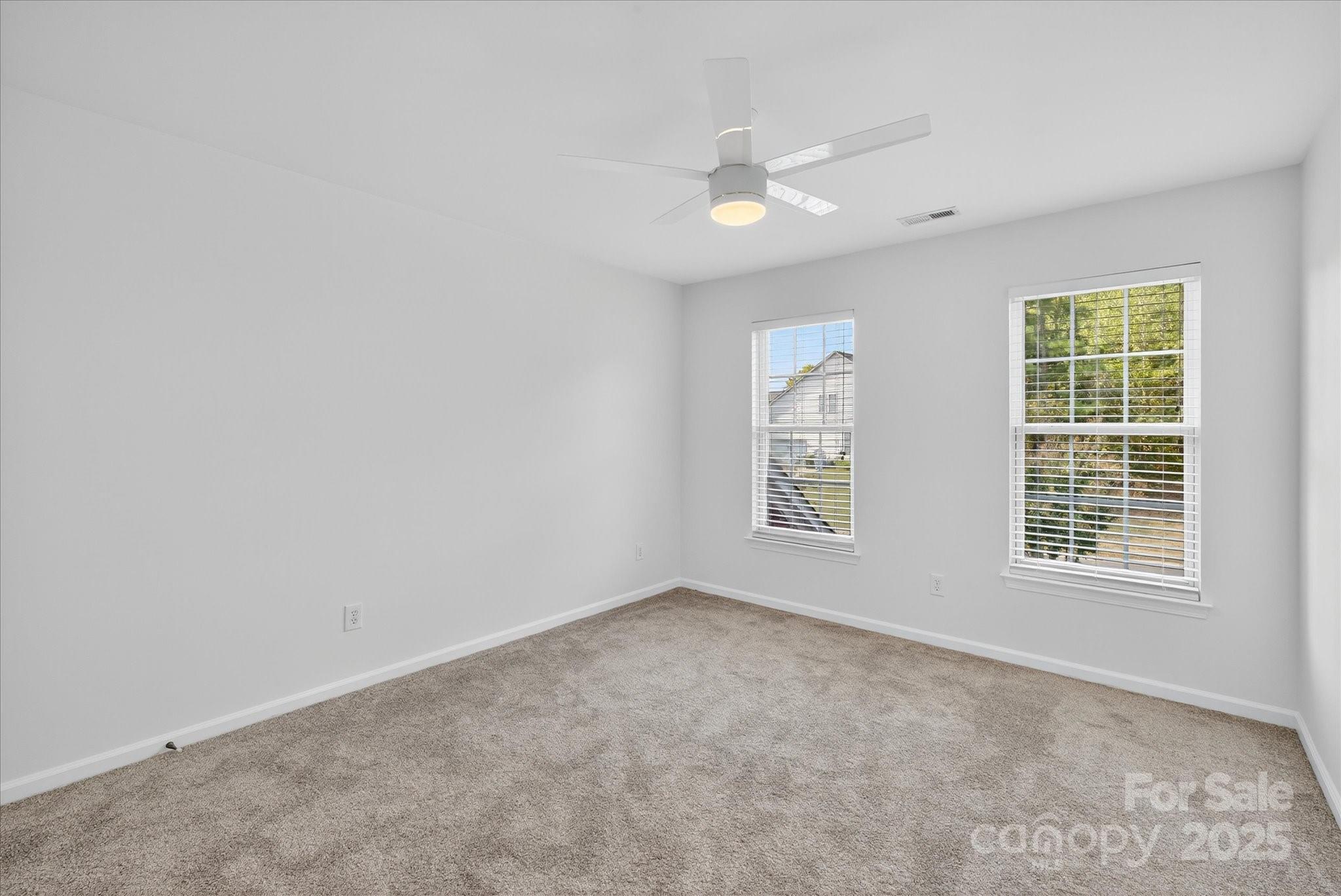 209 Whitegrove Drive Fort Mill, SC 29715 - Photo 30 of 48 an empty room with chandelier fan and windows