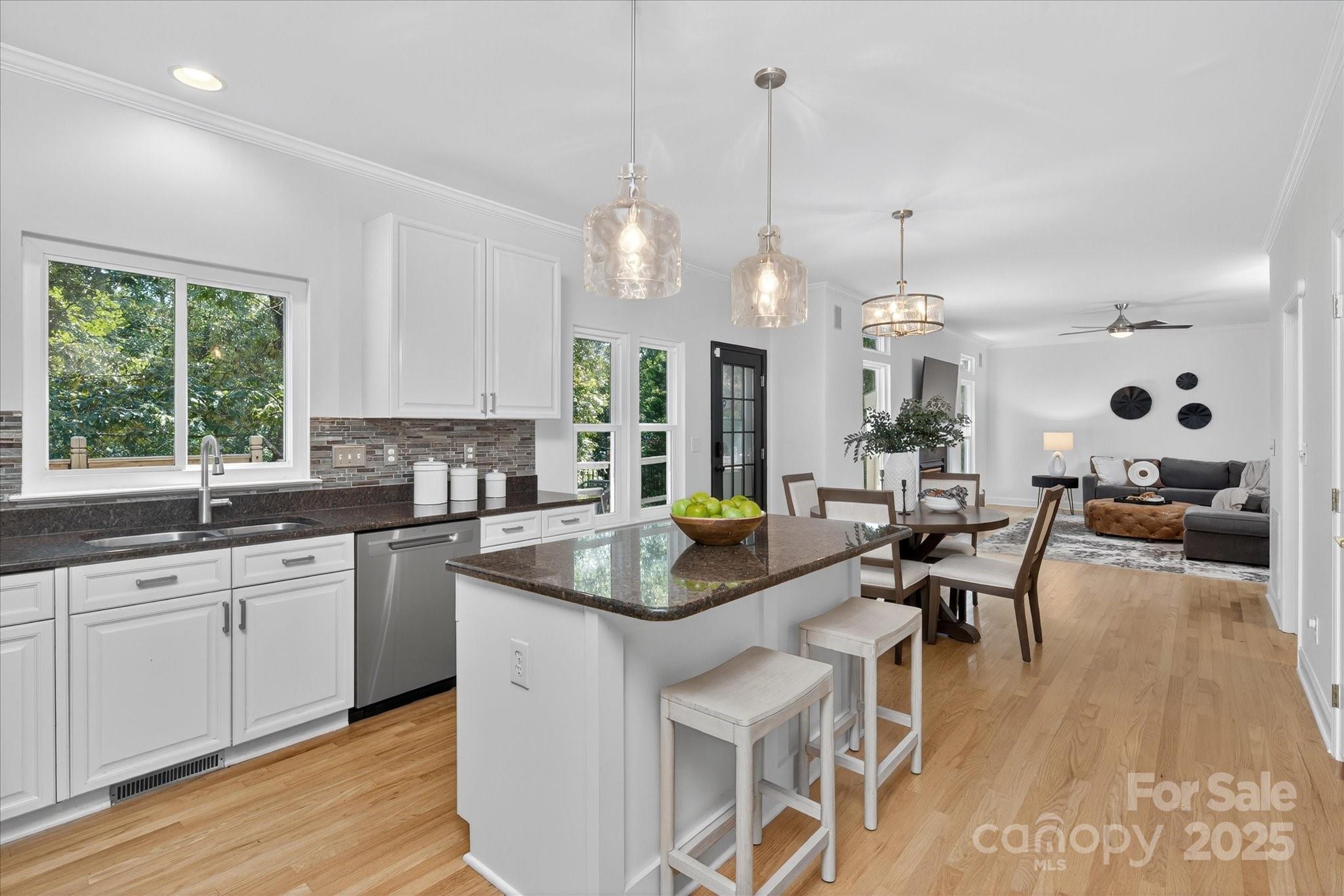 209 Whitegrove Drive Fort Mill, SC 29715 - Photo 9 of 48 a kitchen with granite countertop a stove a sink a dining table and chairs with wooden floor