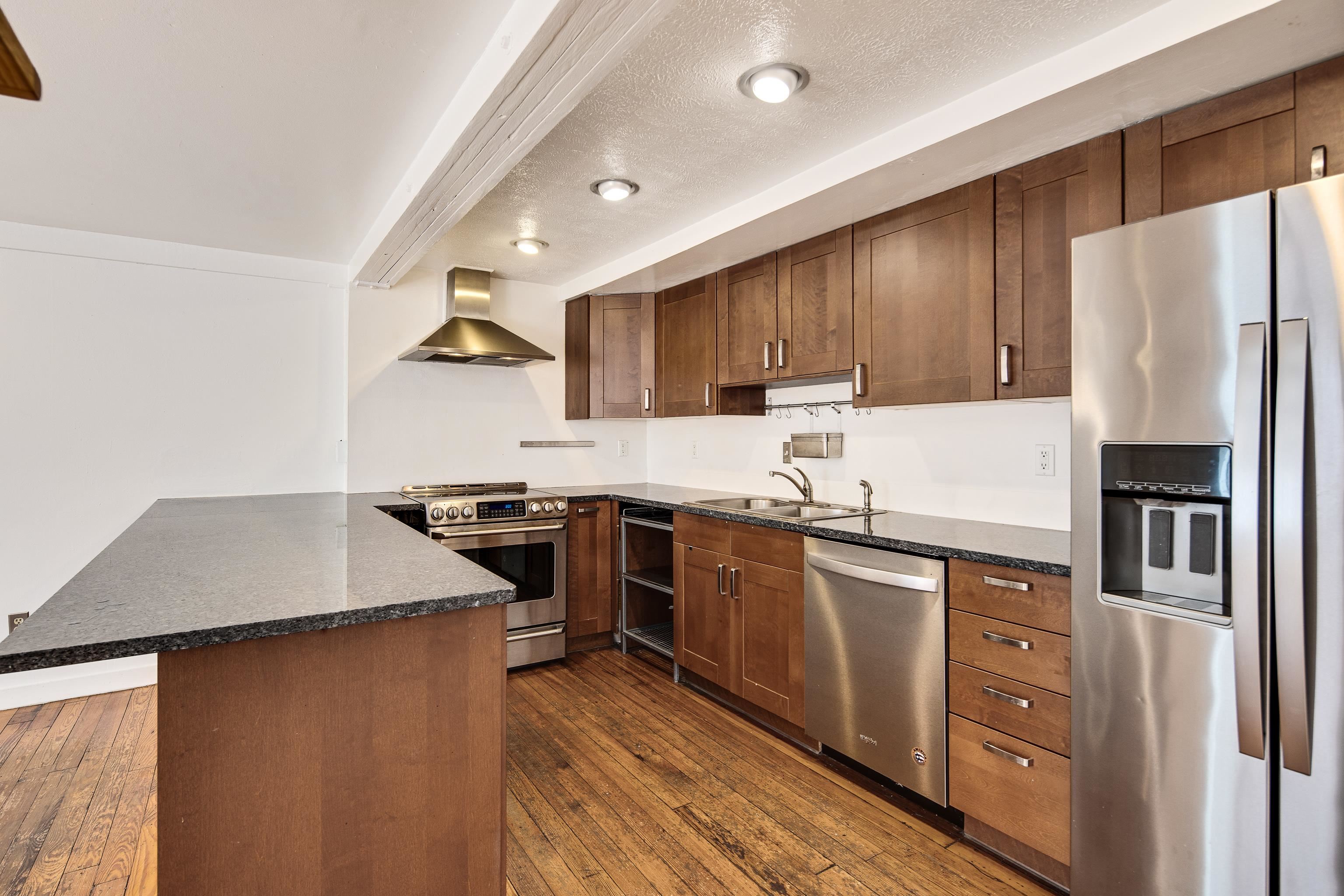 107 South Front Street, Unit 45 Memphis, TN 38103 - Photo 29 of 40 a kitchen with stainless steel appliances granite countertop a refrigerator a stove top oven a sink and dishwasher