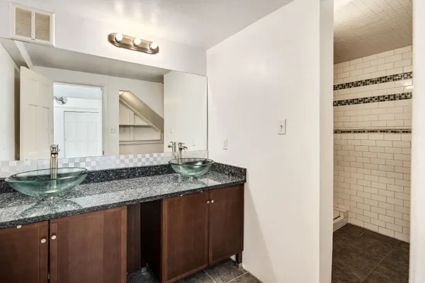 a bathroom with a granite countertop sink and a mirror