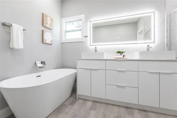 a bathroom with a bathtub a sink and mirror