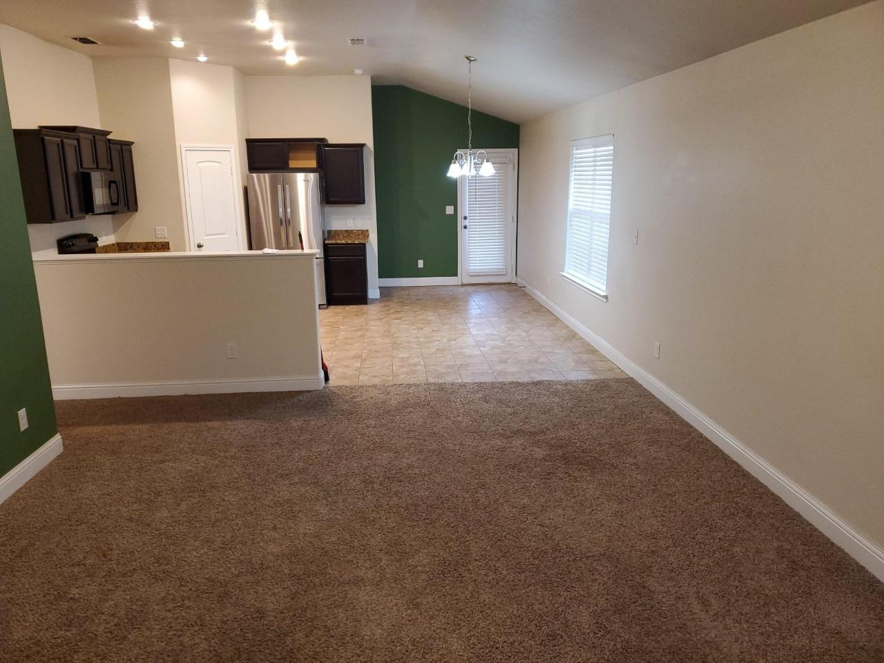 5602 111th Street Lubbock, TX 79424 - Photo 2 of 13 a view of a kitchen with refrigerator and wooden floor