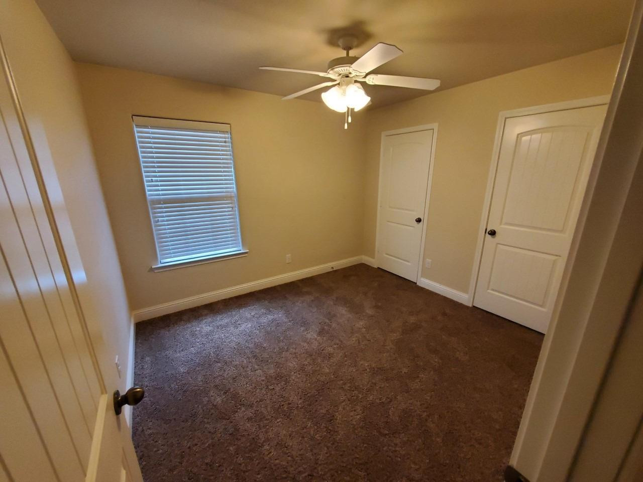 5602 111th Street Lubbock, TX 79424 - Photo 8 of 13 an empty room with windows and fan