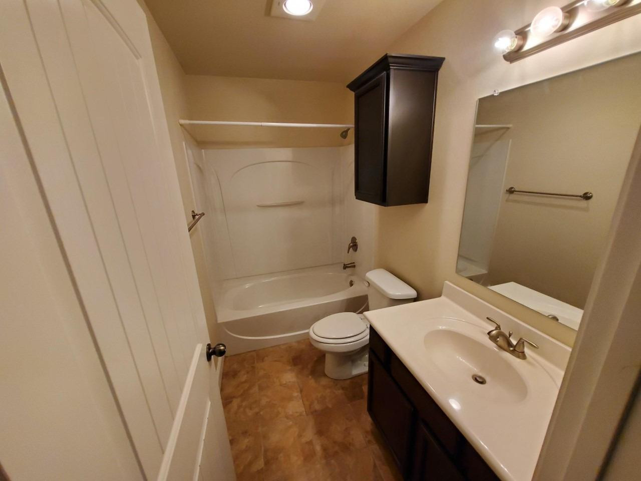 5602 111th Street Lubbock, TX 79424 - Photo 9 of 13 a bathroom with a sink a toilet and shower