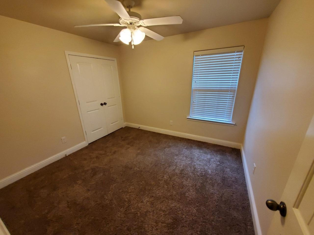 5602 111th Street Lubbock, TX 79424 - Photo 10 of 13 an empty room with a window and a fan