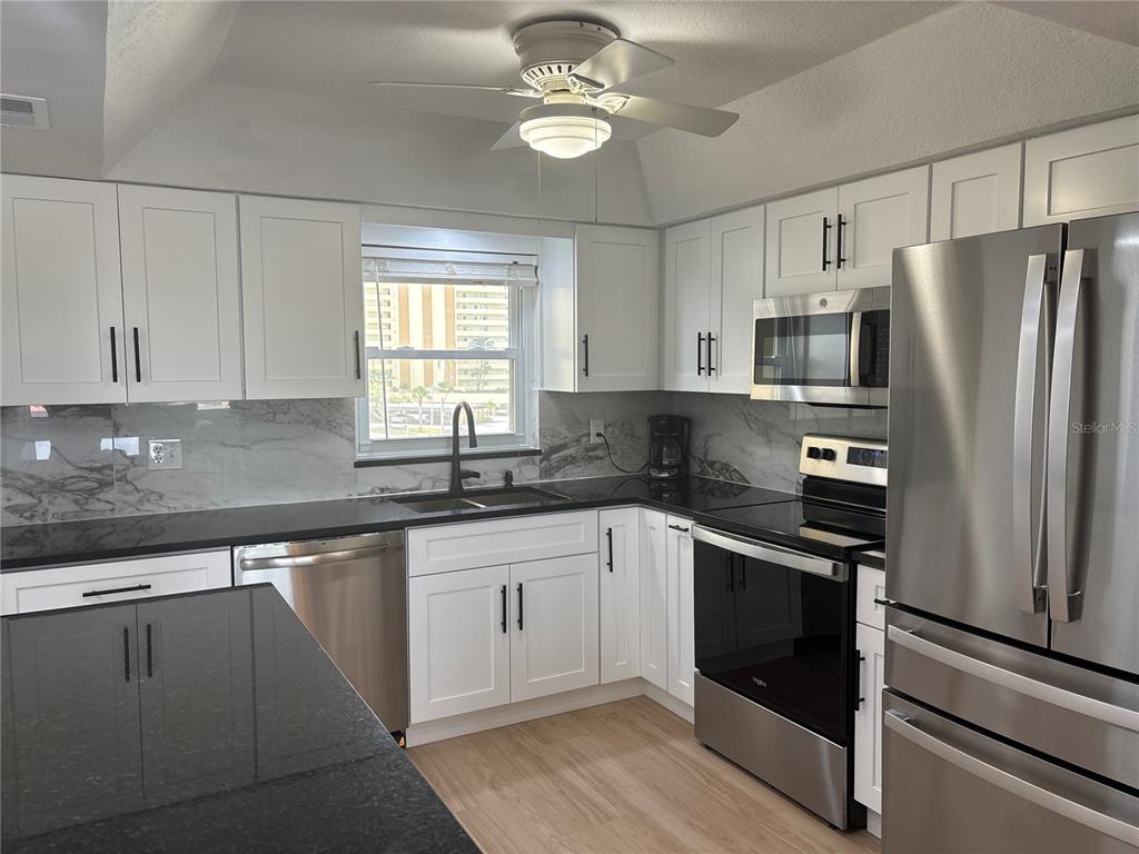 4725 Cove Circle, Unit 405 St. Petersburg, FL 33708 - Photo 5 of 23 a kitchen with cabinets stainless steel appliances a sink and a window