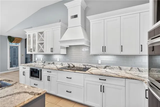 a kitchen with granite countertop a sink a stove and cabinets