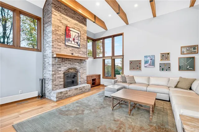 a living room with furniture a fireplace and a large window