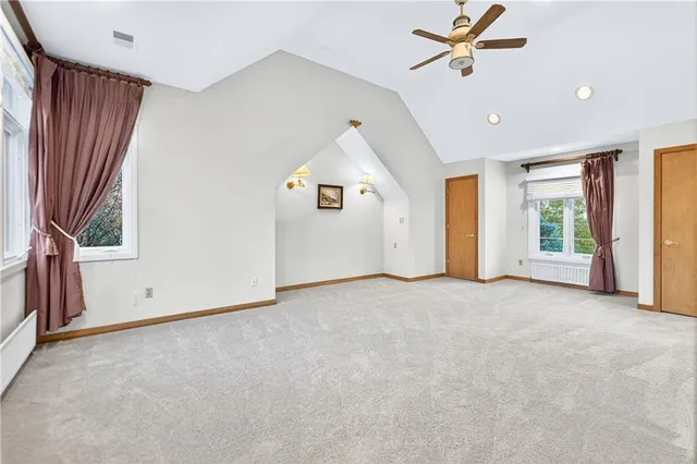 an empty room with windows and cabinet
