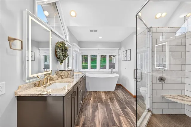 a spacious bathroom with a sink a large mirror and bathtub