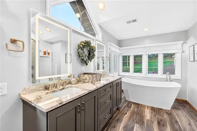 a bathroom with a tub sink and mirror