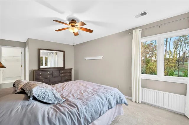 a bed sitting in a bedroom next to a window