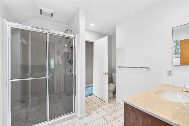 a bathroom with a granite countertop sink toilet and shower