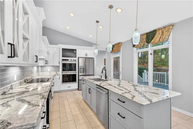 a kitchen with stainless steel appliances granite countertop a stove and more cabinets