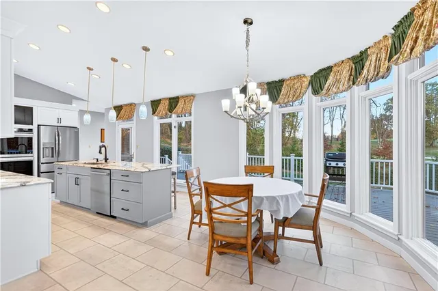 a dining room with furniture a chandelier and kitchen view