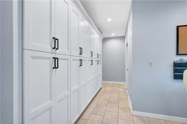 a view of a hallway with white cabinets