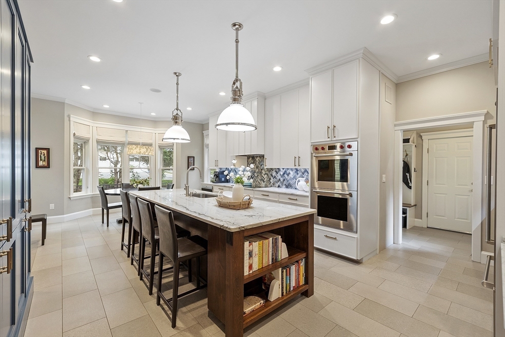 121 Concord Avenue Lexington, MA 02421 - Photo 2 of 42 a kitchen with stainless steel appliances kitchen island granite countertop a table chairs and a refrigerator