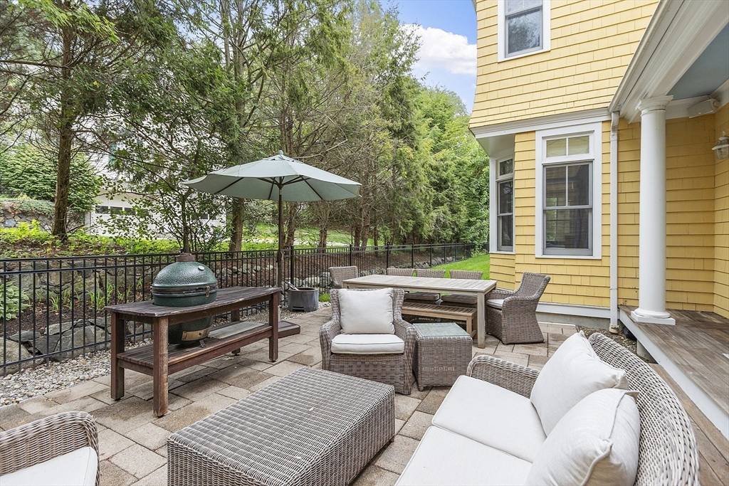 121 Concord Avenue Lexington, MA 02421 - Photo 36 of 42 a view of a patio with couches table and chairs under an umbrella with a barbeque