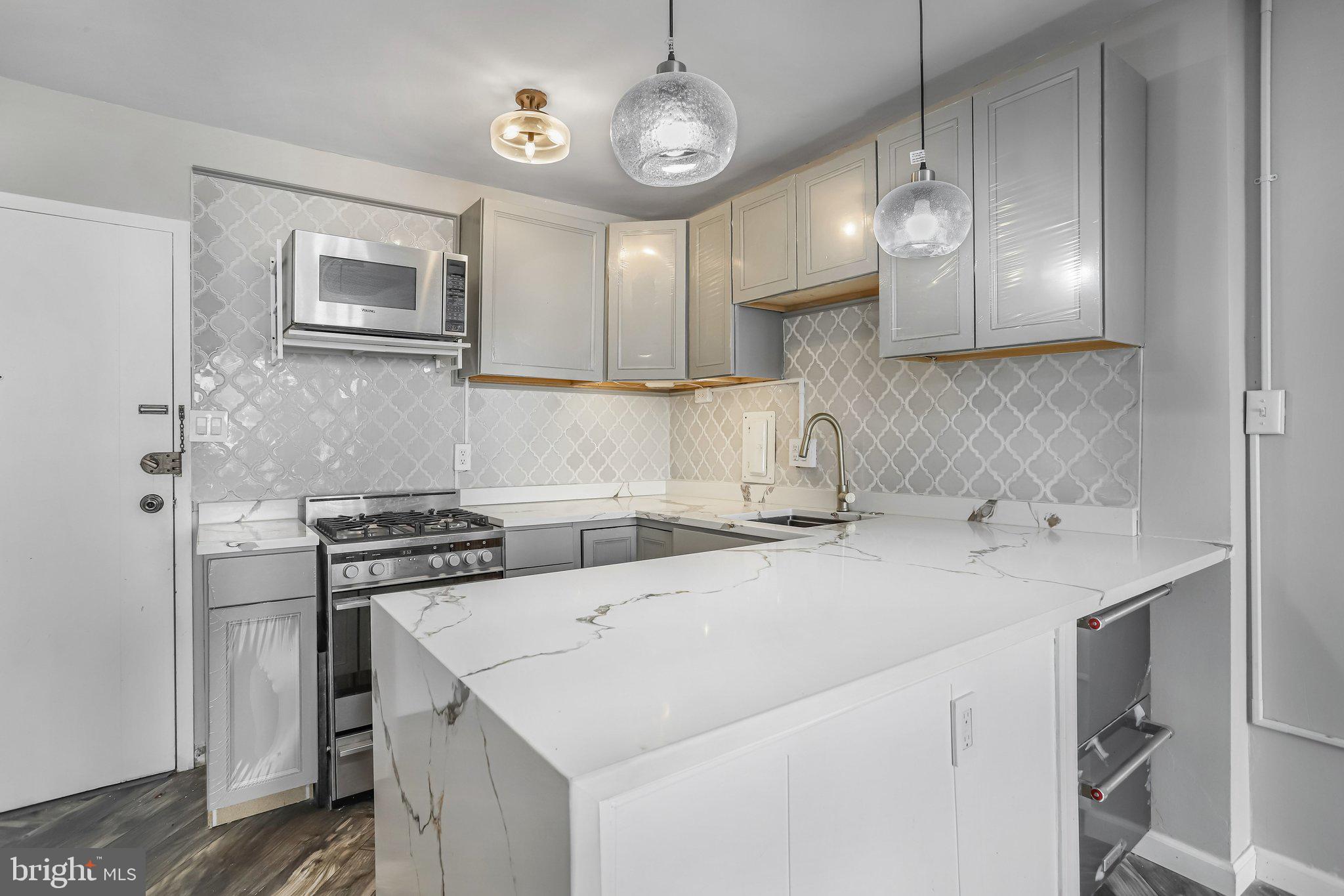 922 24th Street Northwest, Unit 301 Washington, DC 20037 - Photo 20 of 40 a kitchen with stainless steel appliances a stove a sink and a refrigerator