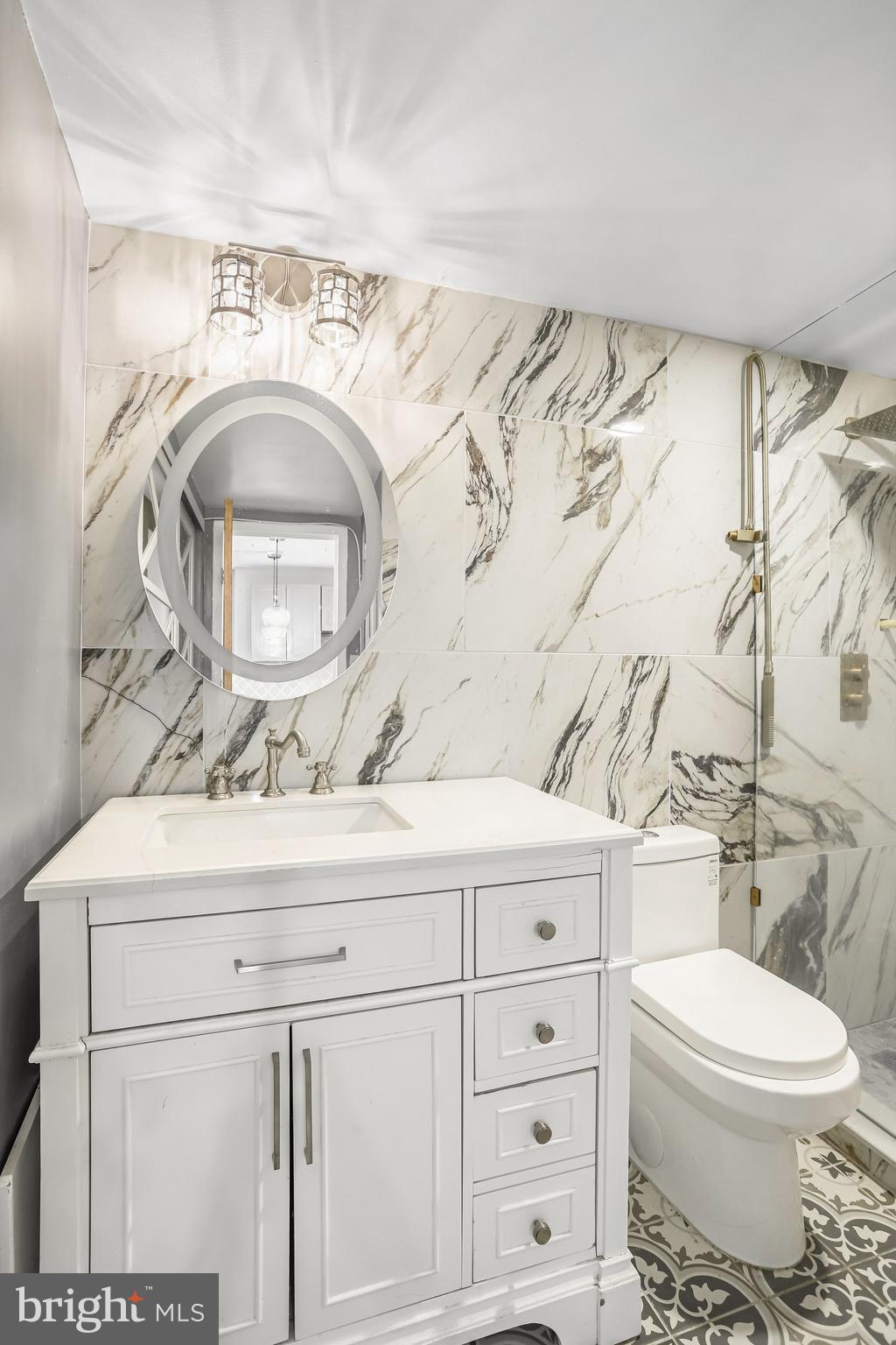 922 24th Street Northwest, Unit 301 Washington, DC 20037 - Photo 34 of 40 a bathroom with a sink mirror vanity and toilet