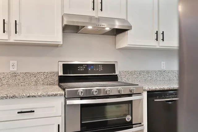 a stove top oven sitting inside of a kitchen