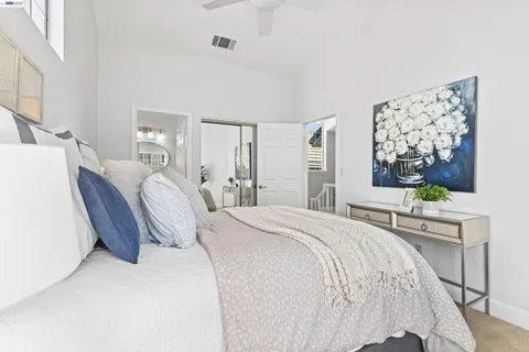a bedroom with a bed and large windows
