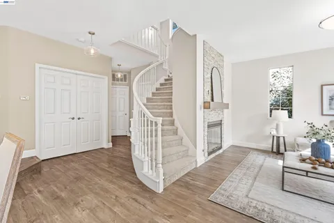 a view of a livingroom with wooden floor and stairs