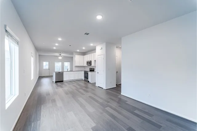 a view of an empty room with wooden floor