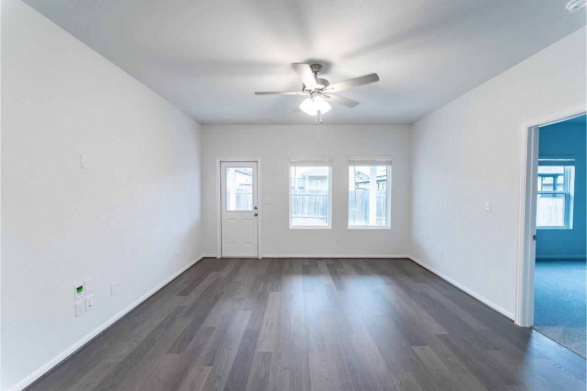 720 Barbary Coast Lane Jarrell, TX 76537 - Photo 6 of 19 a view of an empty room with wooden floor and a window