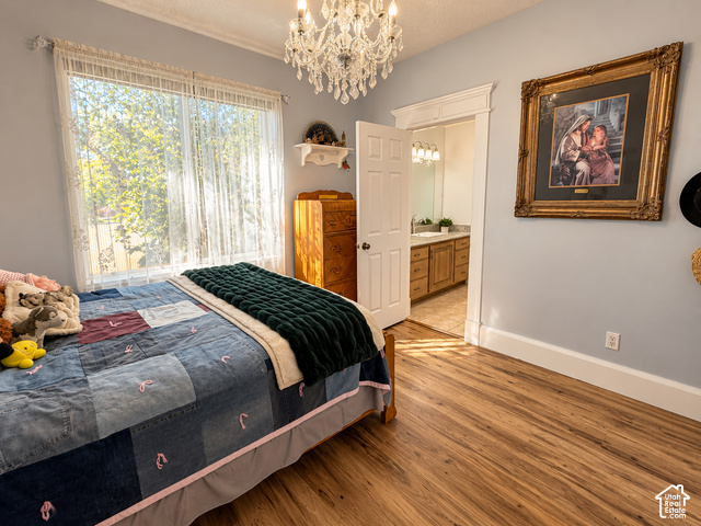 1750 West 4100 North Helper, UT 84526 - Photo 28 of 50 Spacious bedroom featuring hardwood flooring, a crystal chandelier, and abundant natural light from large windows