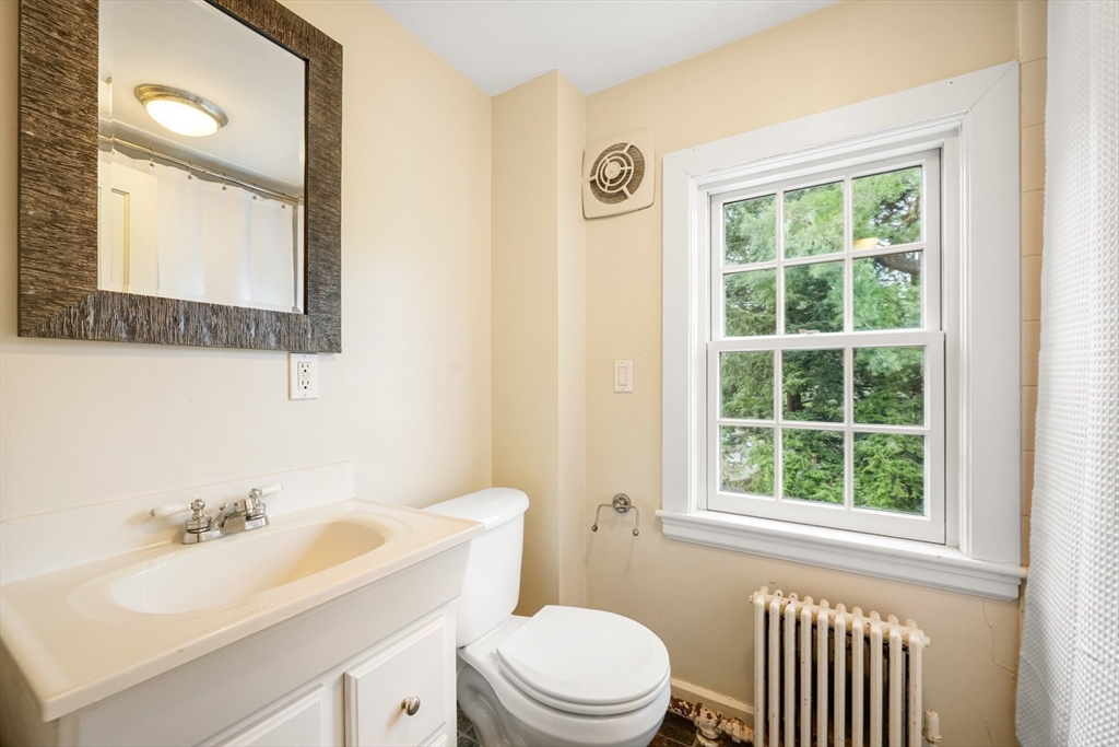 21 Alden Road Wellesley, MA 02481 - Photo 27 of 36 a bathroom with a toilet a sink a mirror a window and vanity