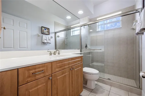 a spacious bathroom with a granite countertop sink a toilet and a mirror