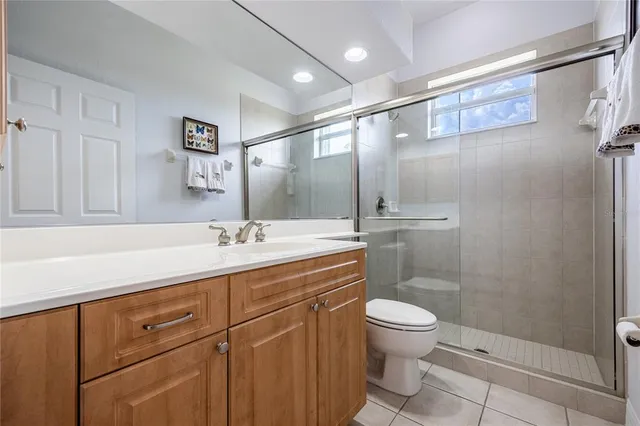 a spacious bathroom with a granite countertop sink a toilet and a mirror