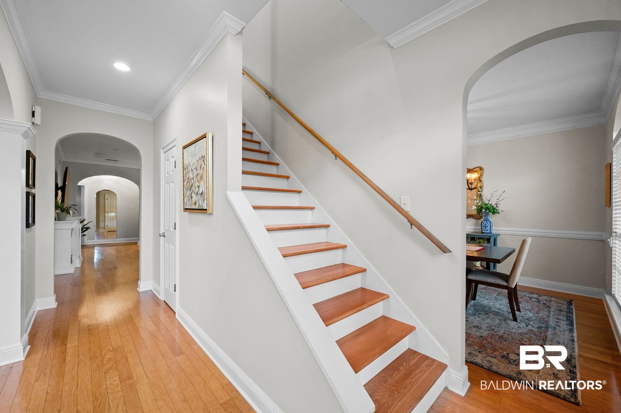 1825 Spring Hill Avenue Mobile, AL 36607 - Photo 16 of 43 Stairway featuring arched walkways, ornamental molding, and hardwood / wood-style flooring