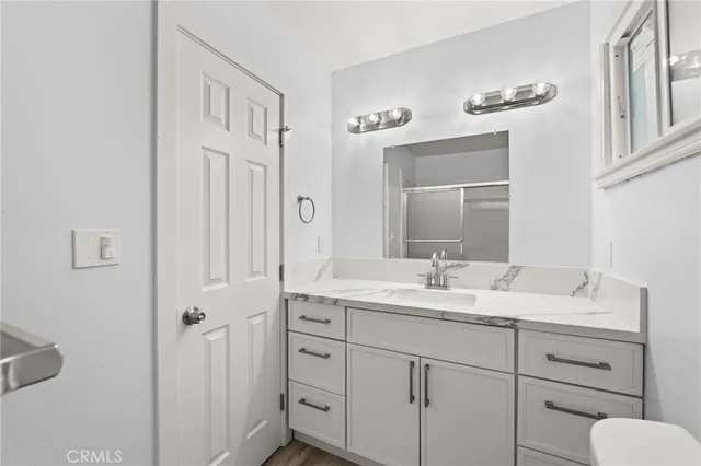 a bathroom with a granite countertop sink vanity and mirror